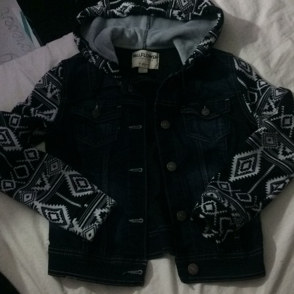 A blue Jean jacket with black and white sleeves.